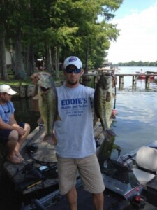 Man in fishing boat holding large mouth bass