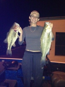 Women at night with two bass fish