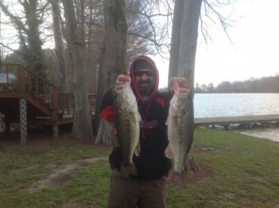 Man holding two bass fish