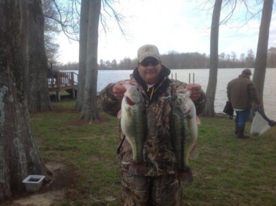 man and two large mouth bass