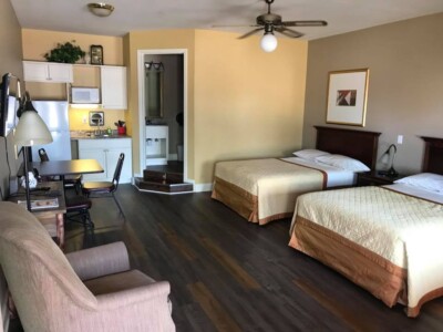 Accommodations room with 2 full size beds, a kitchen, bathroom, and seating
